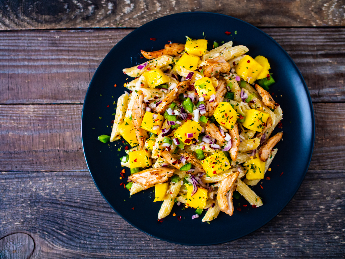 Chicken ragout with penne on wooden table