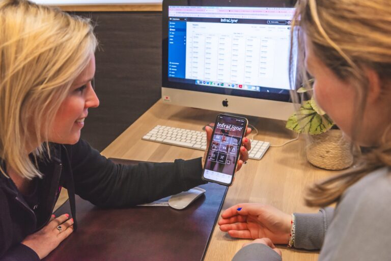 Een coach van InfraLigne legt alle mogelijkheden van de InfraLigne app uit aan een klant
